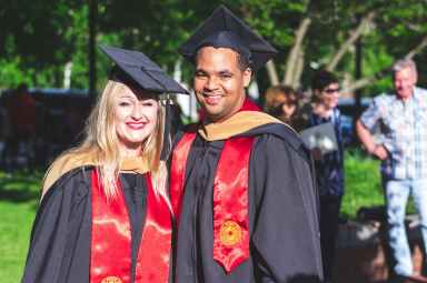 man and woman in black and red toga gown standing side by side
